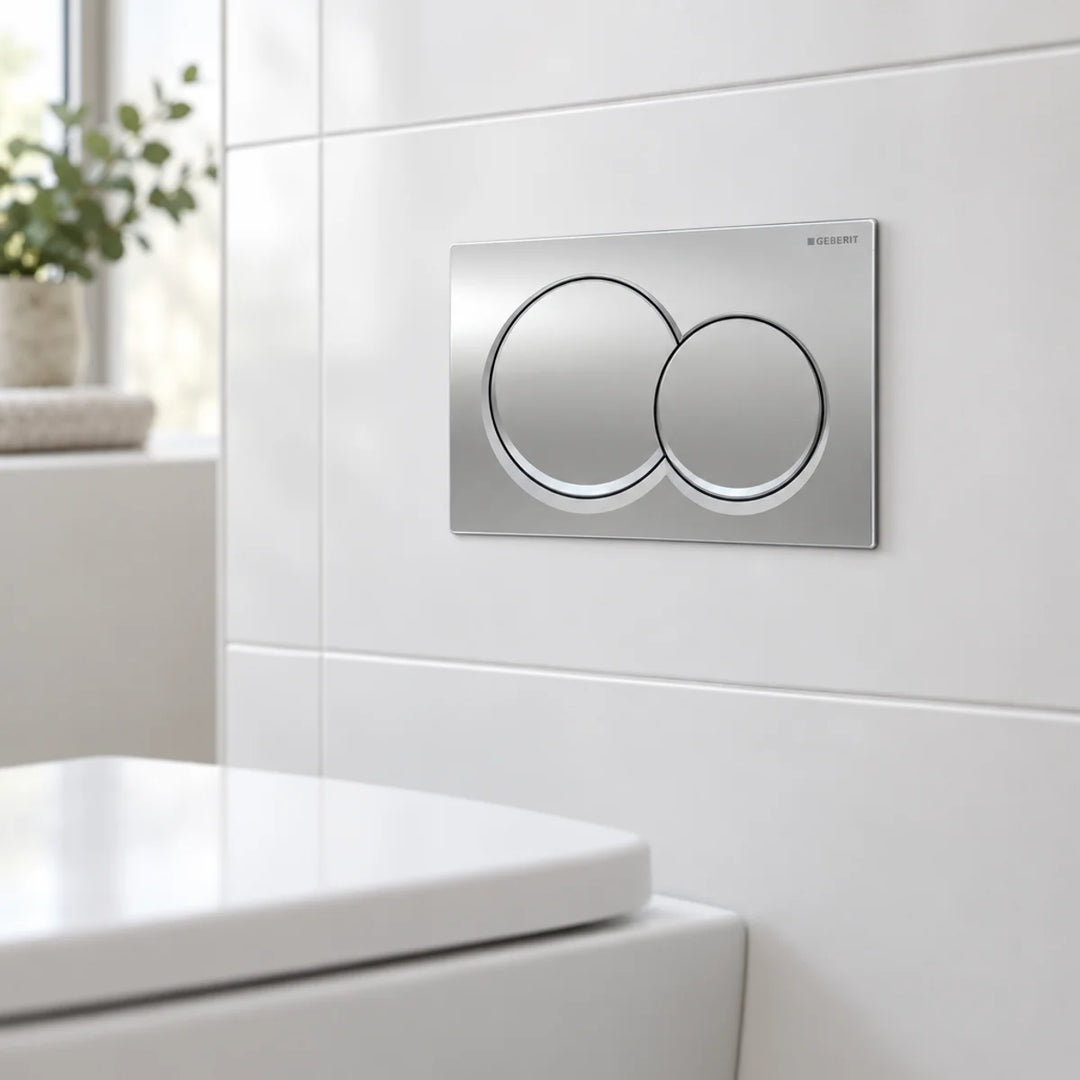 Geberit Alpha01 round dual flush plate in chrome, fitted to white wall tiles above a toilet in a bright bathroom
