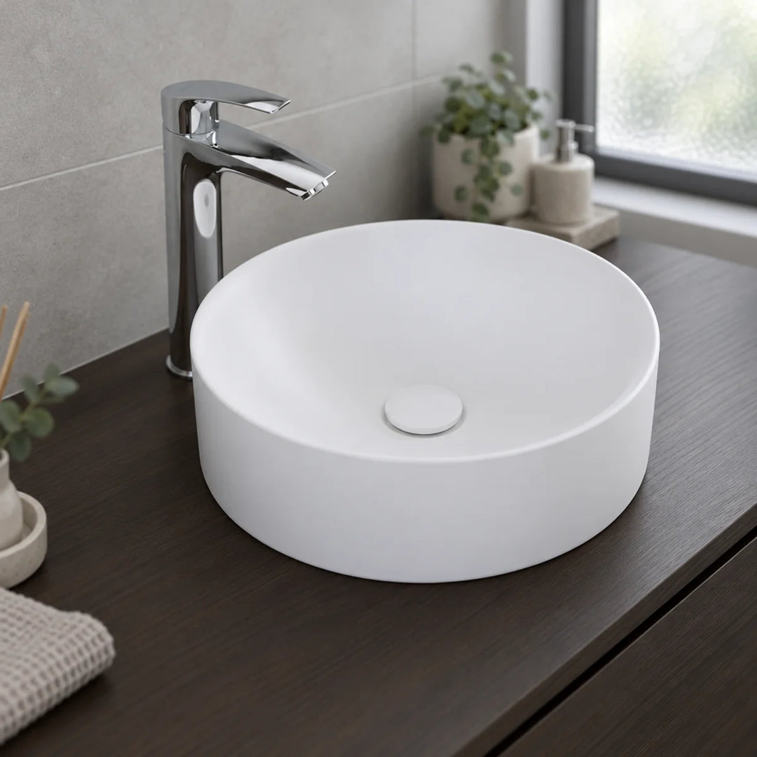 Duravit Durapoint round washbowl in matt white on a dark wood countertop with a tall chrome mixer tap, shown in a bathroom