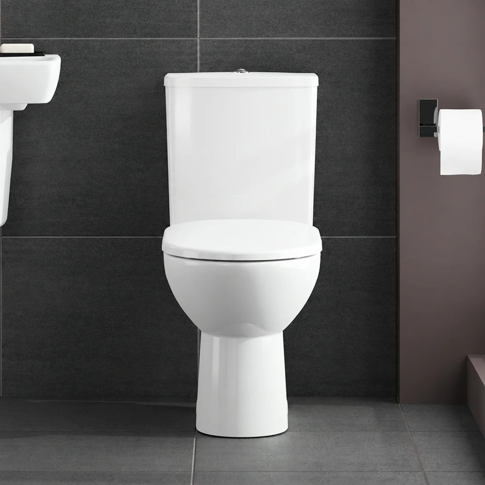 Geberit Selnova close-coupled toilet in white with soft close seat, front view in dark-tiled bathroom