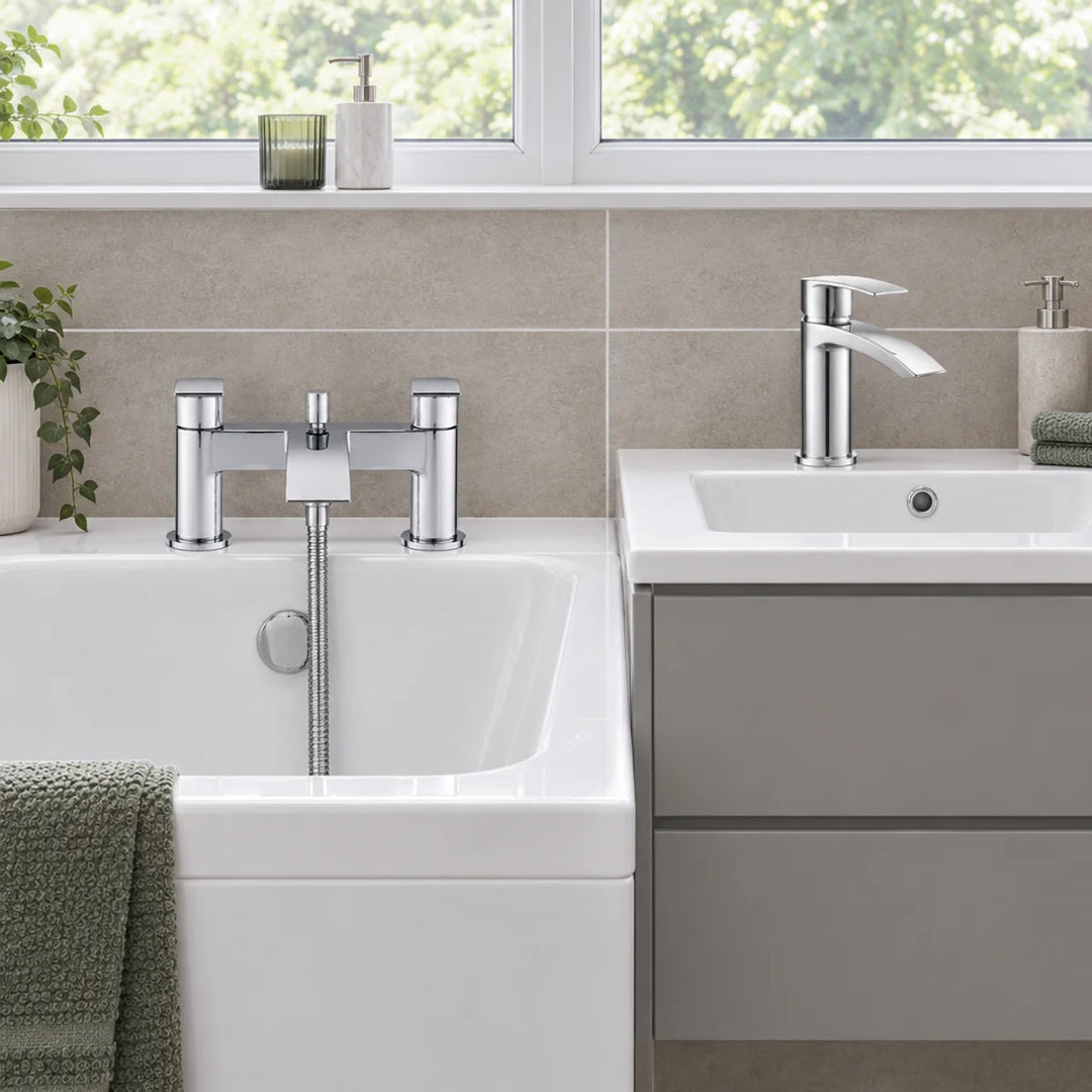 Tre Mercati Ripley chrome bath shower mixer and basin tap installed on a white bath and grey vanity unit in a bathroom