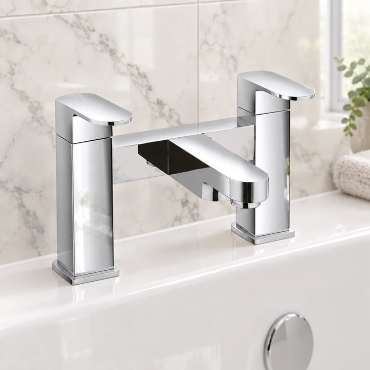 Eliseo Ricci Neo bath filler tap in chrome with two lever handles, installed on a white bath edge against marble-effect tiles