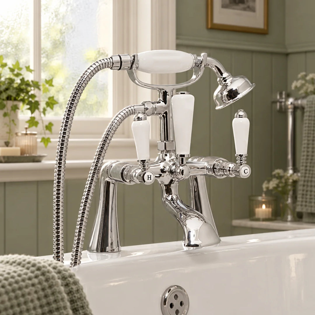 Eliseo Ricci Newbury bath shower mixer in chrome with white ceramic handles, shown on a bath in a sage green panelled bathroom