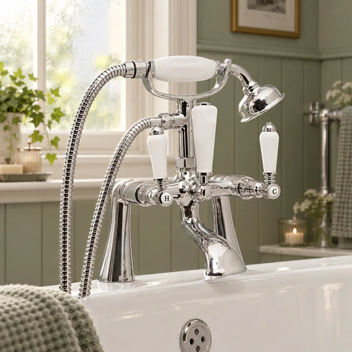 Eliseo Ricci Newbury bath shower mixer in chrome with white ceramic handles, shown on a bath in a sage green panelled bathroom