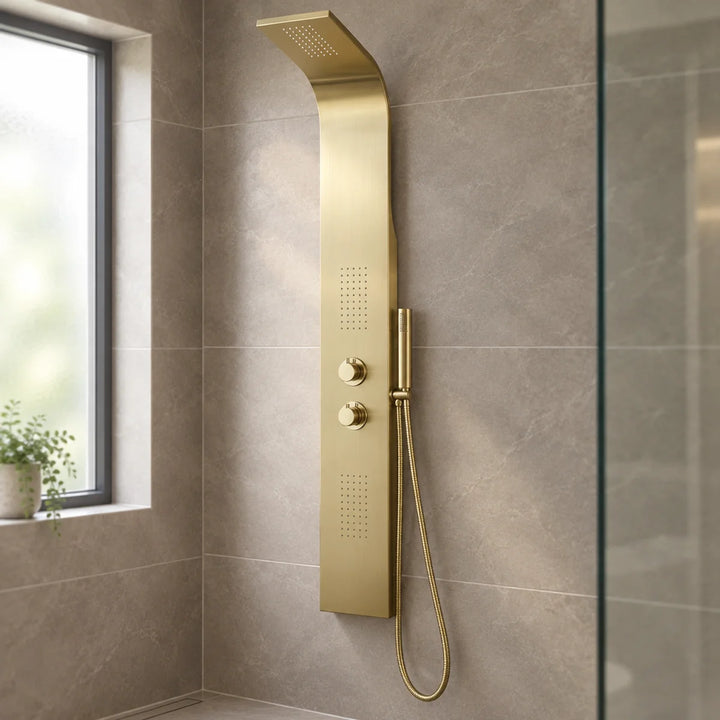 Eliseo Ricci Vesu shower tower in brushed brass with two dials and hand shower, fitted to a taupe tiled wall beside a window