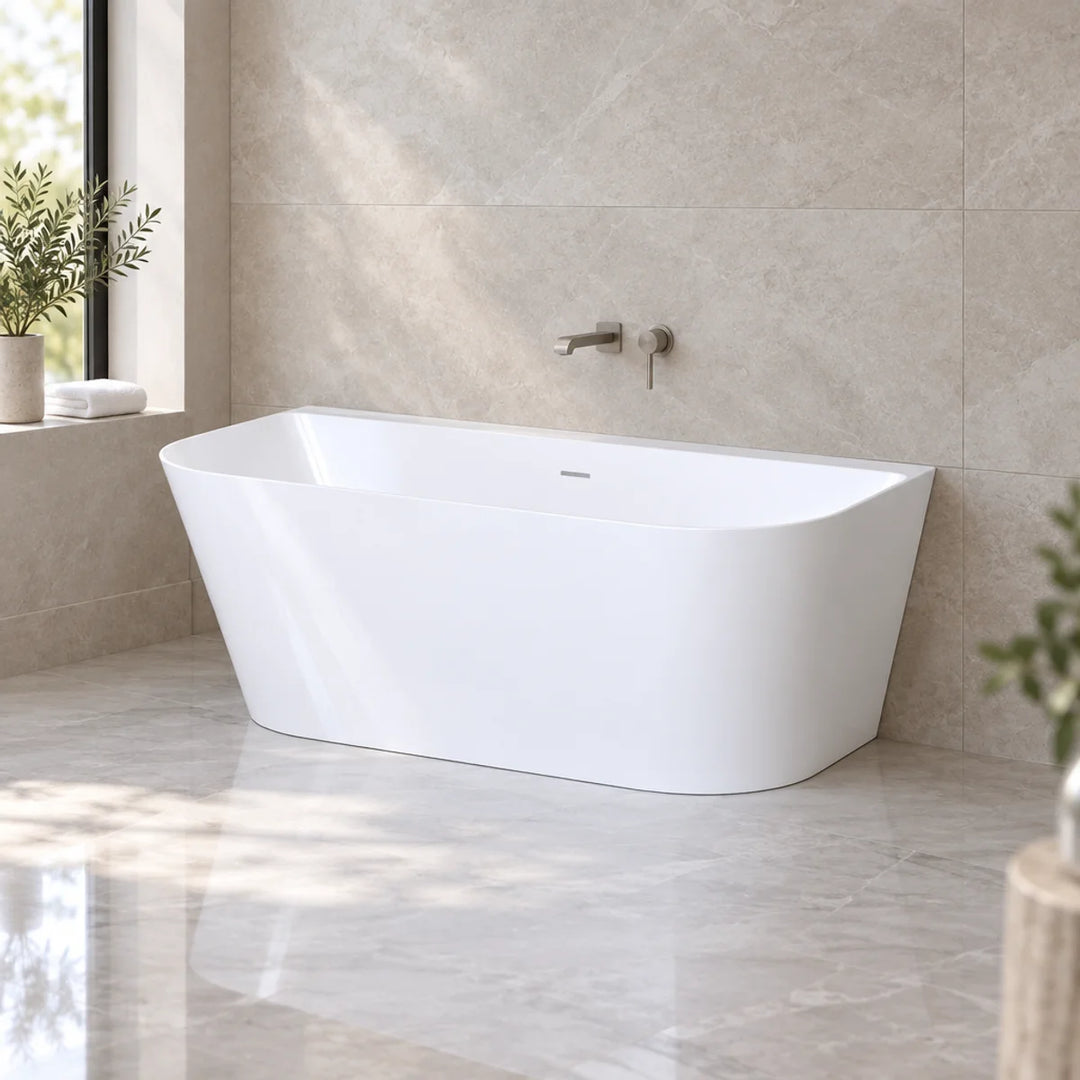 Viktor Benson Athens freestanding bath in gloss white, angled against stone-tiled wall in bright marble-floored bathroom