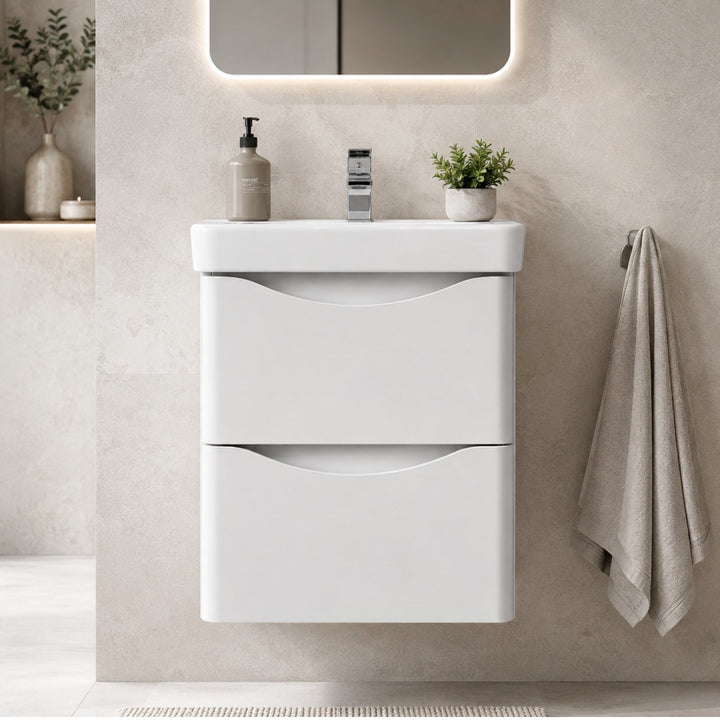 A modern white two-drawer wall hung bathroom vanity with an integrated sink.