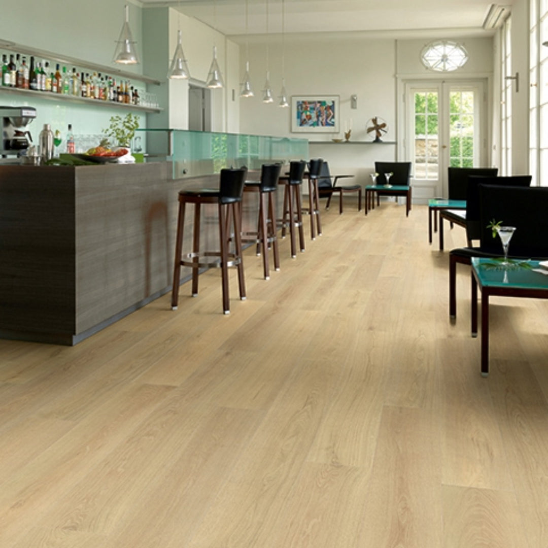 Blonde Montreux Oak 12mm laminate flooring with long, wide 2003 x 245mm planks, warm natural oak tones and authentic embossed wood texture.
