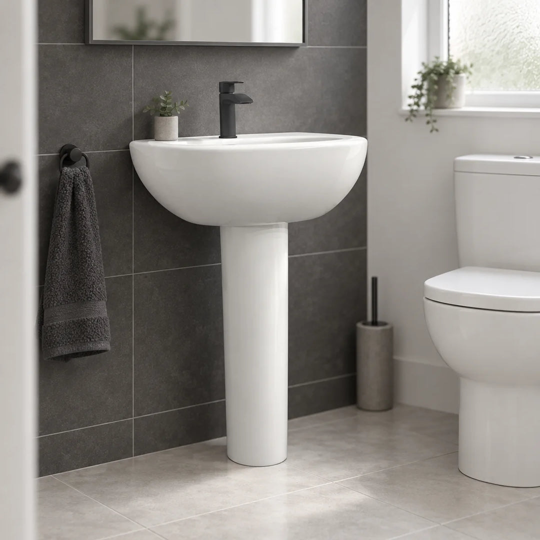 Olympia Nicole white 60cm basin and pedestal with black mono mixer tap, shown in a bathroom with dark grey wall tiles