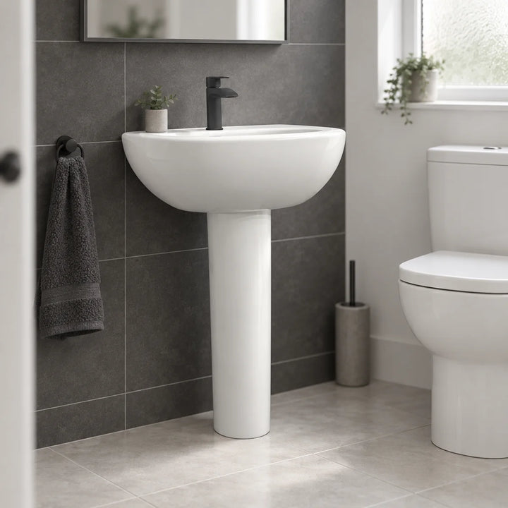 Olympia Nicole white 60cm basin and pedestal with black mono mixer tap, shown in a bathroom with dark grey wall tiles