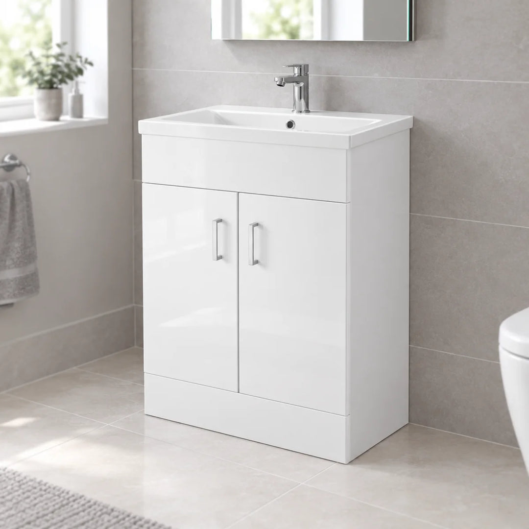 Nuie gloss white floor standing vanity unit with basin and chrome mono tap, shown in a neutral tiled bathroom with window and towel