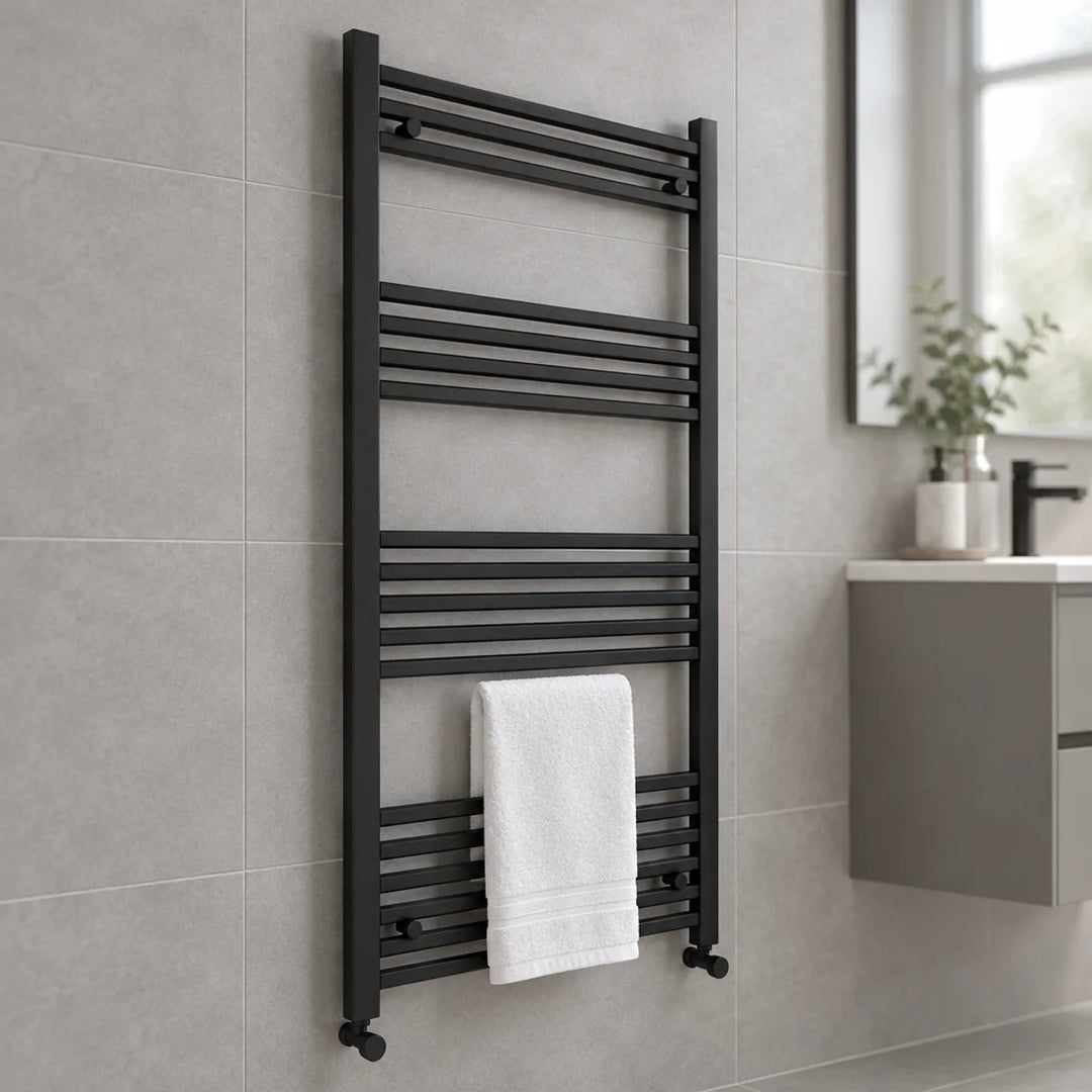 Eliseo Ricci straight heated towel rail in anthracite with a white towel, mounted on a grey tiled bathroom wall