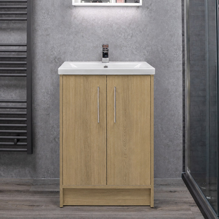 A modern floor standing bathroom vanity cabinet with a light oak wood grain finish, featuring two doors and a white ceramic sink basin.