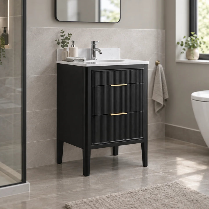 Wilde Fluted 600mm floor standing vanity unit in black with gold handles, white basin, styled in a neutral grey bathroom